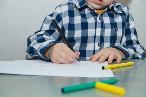 Little boy drawing with felt-tip pens on paper. Developmental activities.