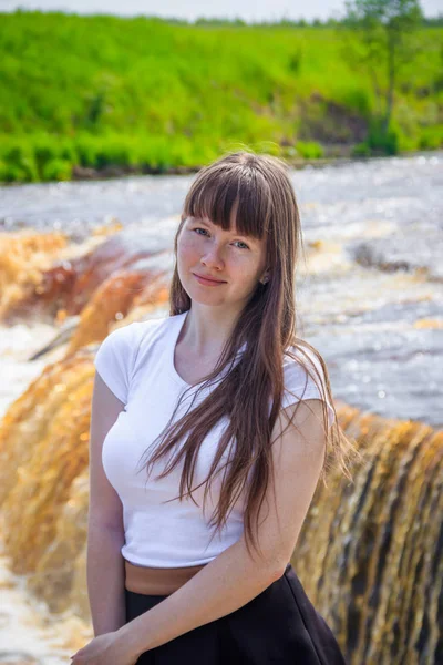 portrait of young beautiful woman at the waterfall, Russia