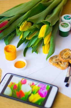 Laleler, kağıt, fırçalar ve guaj boyaları. Bir Mart 8 kartpostal kavramı çizin. Kadınlar tatili