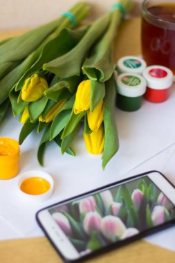 Laleler, kağıt, fırçalar ve guaj boyaları. Bir Mart 8 kartpostal kavramı çizin. Kadınlar tatili