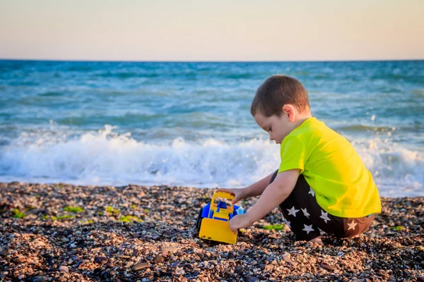 Piccolo Ragazzo Che Gioca Sulla Spiaggia Ghiaia Con Giocattoli Colorati — Foto Stock