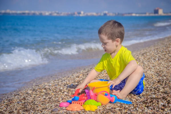 Piccolo Ragazzo Che Gioca Sulla Spiaggia Ghiaia Con Giocattoli Colorati — Foto Stock
