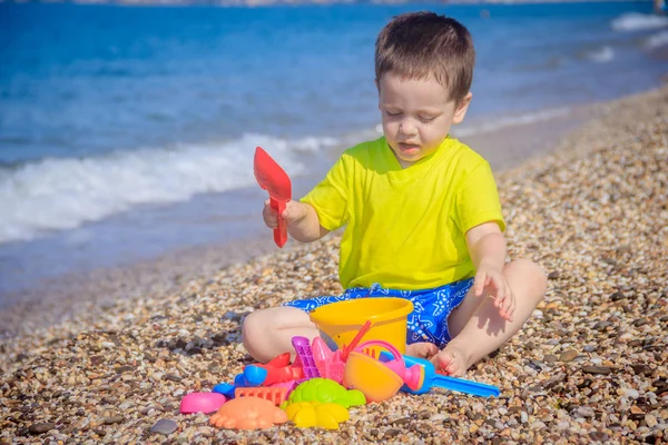 Piccolo Ragazzo Che Gioca Sulla Spiaggia Ghiaia Con Giocattoli Colorati — Foto Stock