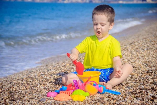 Piccolo Ragazzo Che Gioca Sulla Spiaggia Ghiaia Con Giocattoli Colorati — Foto Stock