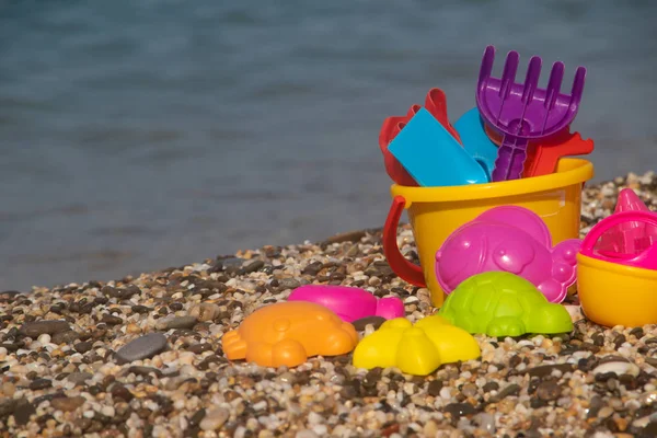 Giocattoli Plastica Colorati Bambini Sdraiati Sulla Spiaggia Ghiaia Sullo Sfondo — Foto Stock