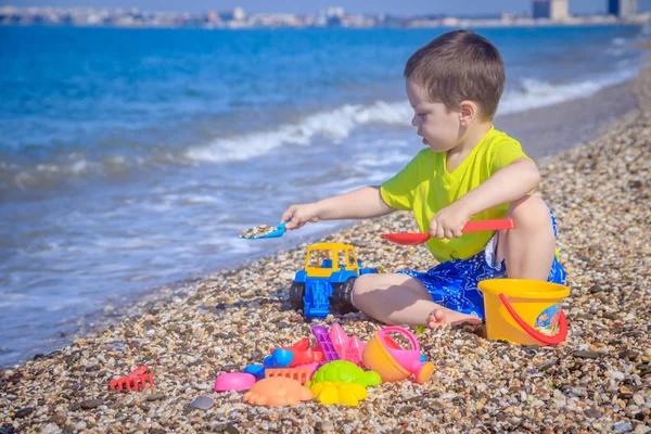 Piccolo Ragazzo Che Gioca Sulla Spiaggia Ghiaia Con Giocattoli Colorati — Foto Stock