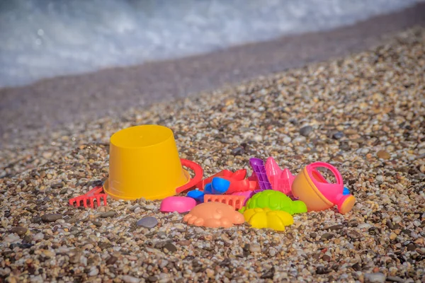 Giocattoli Plastica Colorati Bambini Sdraiati Sulla Spiaggia Ghiaia Sullo Sfondo — Foto Stock