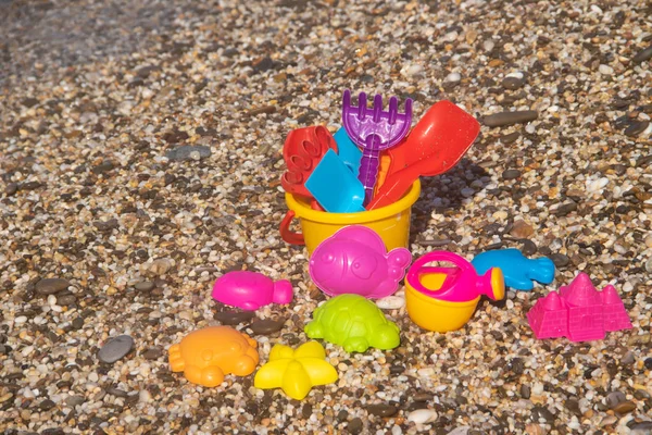 Kleurrijk Plastic Speelgoed Voor Kinderen Liggend Kiezelstrand Zee Achtergrond — Stockfoto