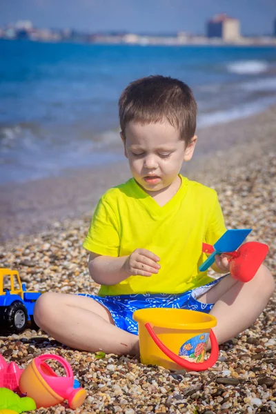 Piccolo Ragazzo Che Gioca Sulla Spiaggia Ghiaia Con Giocattoli Colorati — Foto Stock