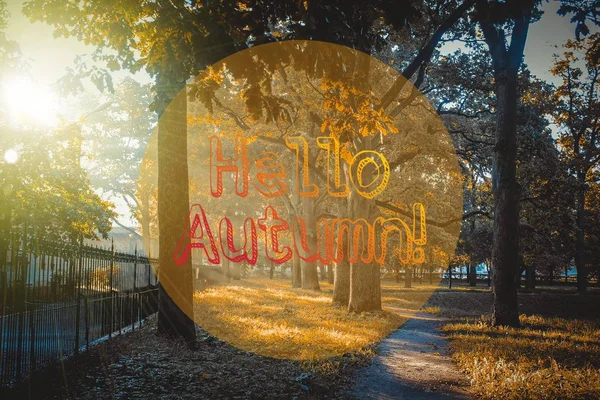 Привет, осень. Новый месяц. Поздравительная открытка. Золотая осень. Осень в парке. Текст на фото. Деревья осеннего парка . — стоковое фото