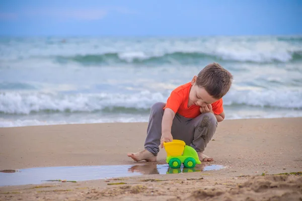 Ragazzino Che Gioca Con Macchina Giocattolo Plastica Sulla Spiaggia Sabbiosa — Foto Stock