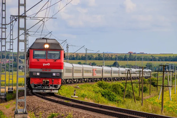 Rosyjski pociąg podróżuje koleją. Przejażdżki pociągiem pasażerskim przez pola. Kolej Rosyjska. Lokomotywa. Rosja, Anapa, 16 lipca 2019 — Zdjęcie stockowe