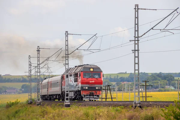 Rosyjski pociąg podróżuje koleją. Przejażdżki pociągiem pasażerskim przez pola. Kolej Rosyjska. Lokomotywa. Rosja, Anapa, 16 lipca 2019 — Zdjęcie stockowe