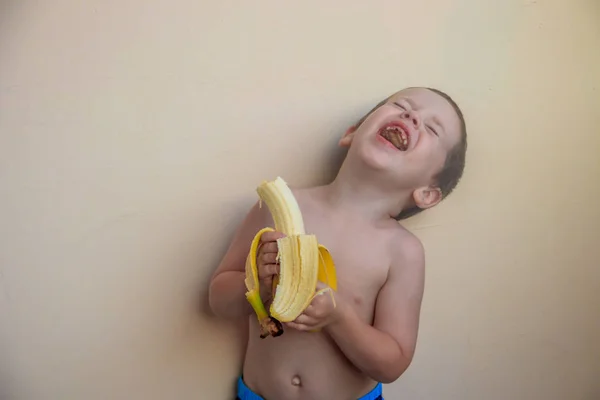 Милый Мальчик Ест Банан Пастельном Фоне — стоковое фото