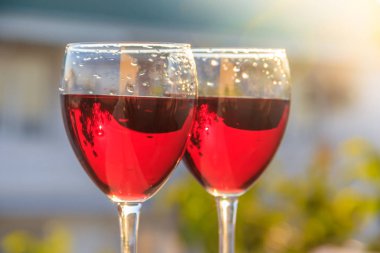 bulanık arka planda kırmızı şarap ile iki bardak yakın 