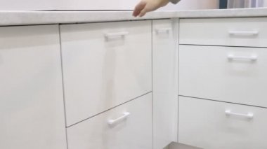 Beyaz kadın modern mutfağı gösteriyor. Güzel mutfak..