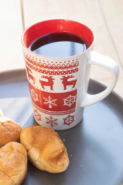 Kaffee in einer Tasse und Croissants auf einem Teller. Essen und Trinken. Teller auf einem hölzernen Hintergrund. — Stockfoto