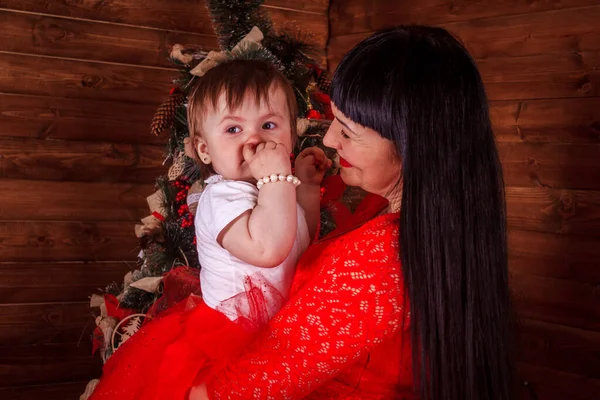 Anne ve kızı yeni yıl ağacının altında oturuyorlar. Noel ailesi. Yeni yıl tatili. Giyinik Noel ağacı. — Stok fotoğraf