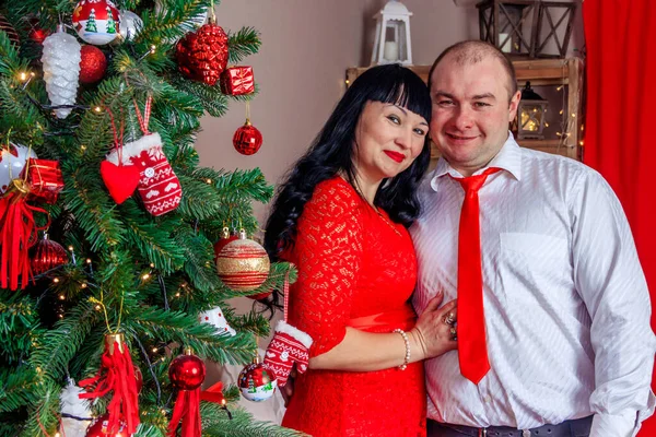 夫と妻は新年の木の下に座って クリスマス休暇の概念 — ストック写真