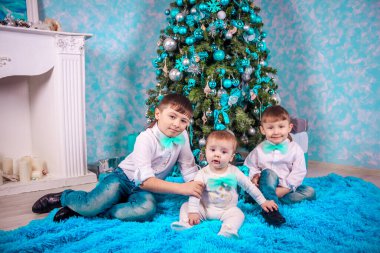 Noel ağacı arka planında üç kardeş, yeni yıl tatili konsepti 