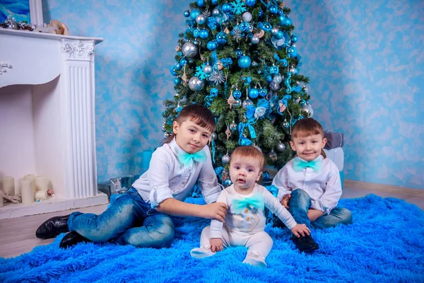 Three brothers on Christmas tree background, New Year holidays concept