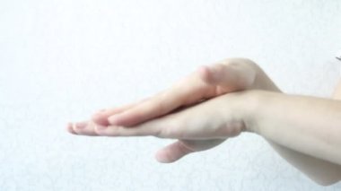 Hafif bir arka planda ellere krem sürmek. El bakımı. Dişi genç eller. Krem sür. Elleri nemlendiriyor. Sağlıklı güzel cilt