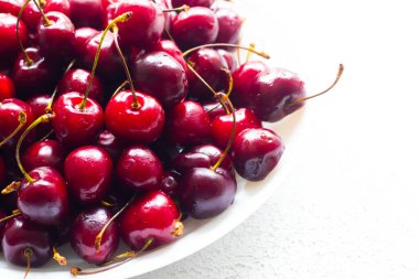 Beyaz tabakta kiraz çileği. Yaz meyvesi. Beyaz arka planda bir tabakta böğürtlen. Böğürtlenler hakkında. Çilek mevsimi.