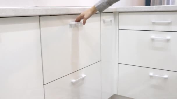 Una mano de mujer abre un cajón en la mesa de la cocina. Cocina luminosa. Cajones de cocina extraíbles. Cajas con cierrapuertas. Accesorios de muebles modernos. .. Rusia, San Petersburgo 10 julio 2020 — Vídeo de stock