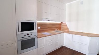 Hareket halindeki modern bir ışık mutfağının detayları. Parlak mutfak manzarası. Mutfak vitrini. Videoda hareket var. Mutfak beyaz ve ahşap tezgahı var. Rusya, Saint Petersburg, İç Kesimler