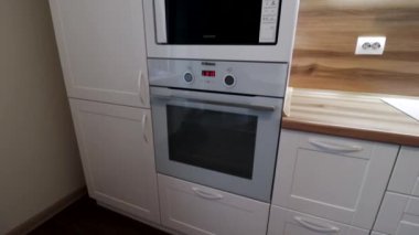 Hareket halindeki modern bir ışık mutfağının detayları. Parlak mutfak manzarası. Mutfak vitrini. Videoda hareket var. Mutfak beyaz ve ahşap tezgahı var. Rusya, Saint Petersburg, İç Kesimler