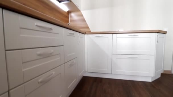 モダンなキッチンの動きの詳細。明るいキッチンの眺め。キッチンディスプレイ。ビデオでの動きキッチンは木製のカウンターで白いです。ロシアサンクトペテルブルク内部 — ストック動画