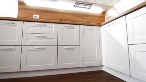 Detaily moderní lehké kuchyně v pohybu. Pohled na světlou kuchyň. Kuchyně. Pohyb ve videu Kuchyně je bílá s dřevěnou deskou. Rusko, Petrohrad, interiér — Stock video