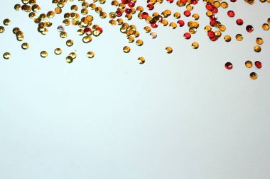 Beyaz arka planda dağınık altın payetler