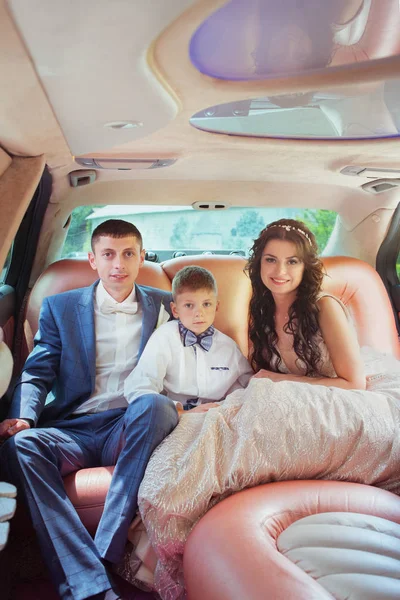 Jovem bela noiva casal caucasiano e noivo com filho no carro — Fotografia de Stock