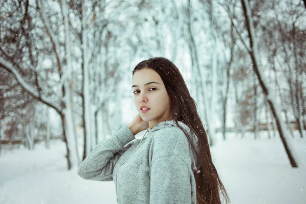 年轻美丽的高加索女孩在雪的背景下, 冬季公园户外 — 图库照片