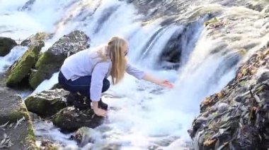 Kız şelale yakınında su dokunur