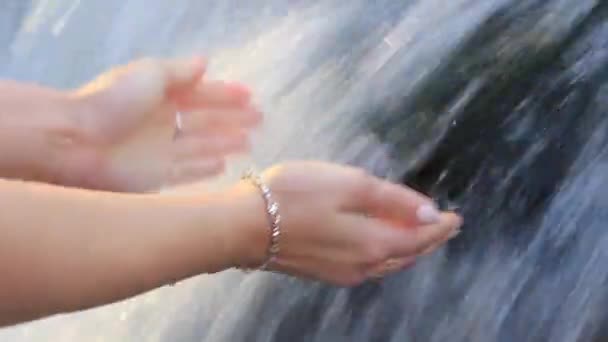 Женские руки в чистой воде водопада — стоковое видео