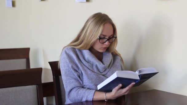Κορίτσι στο αναγνωστήριο διαβάζοντας ένα βιβλίο — Αρχείο Βίντεο