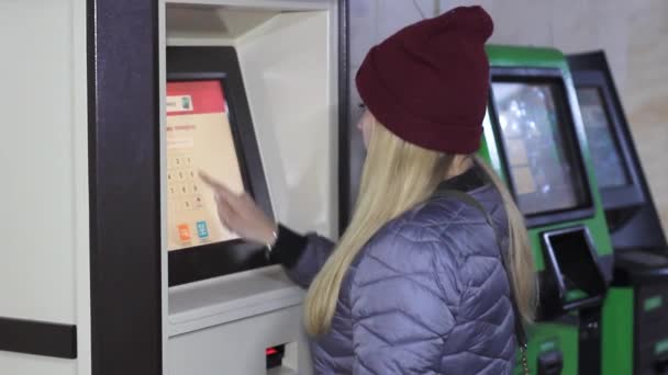 Chica en un cajero automático utiliza una tarjeta — Vídeos de Stock