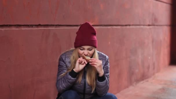 Голодная девочка ест хлеб — стоковое видео