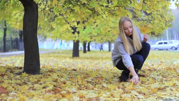 Mädchen im Herbstpark mit Laub — Stockvideo