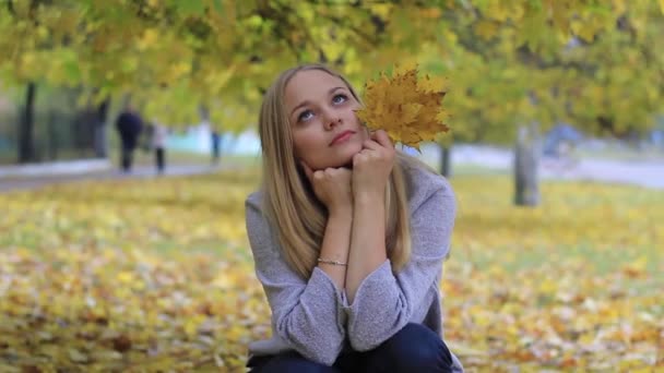 Meisje in herfst park met loof — Stockvideo