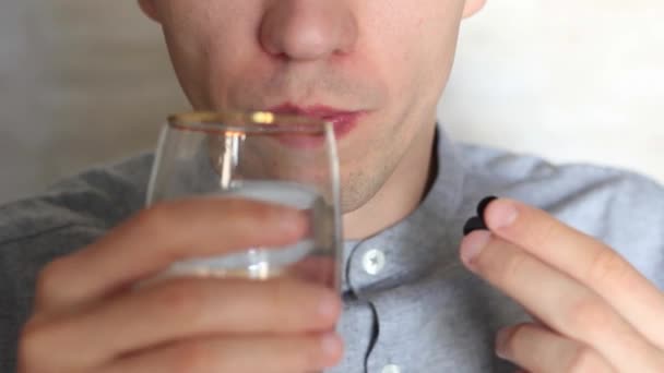 De man drinkt pillen en hen water drinkt — Stockvideo