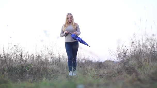 Girl with umbrella on nature — Stock Video