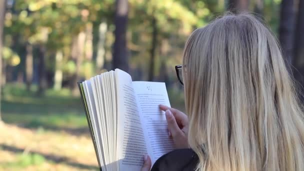 Κορίτσι που διαβάζει ένα βιβλίο στο δάσος — Αρχείο Βίντεο