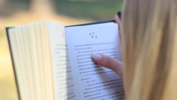 Chica leyendo un libro en el bosque — Vídeo de stock