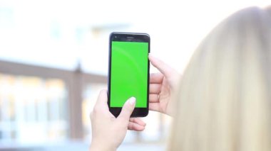 yeşil bir ekran cep telefonuyla holding kızlar eller. Hroma anahtar
