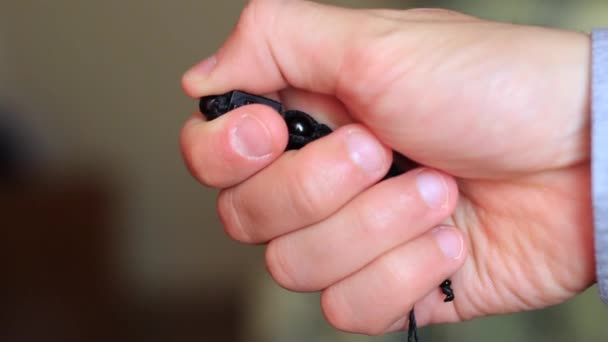 Pequeña cruz negra de madera comprime la mano masculina — Vídeos de Stock