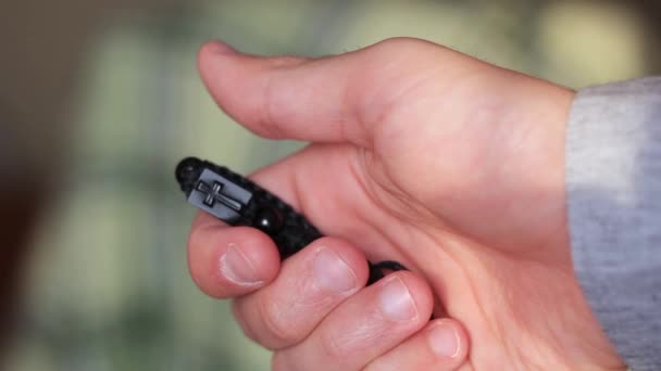 petite croix en bois noir à la main masculine 