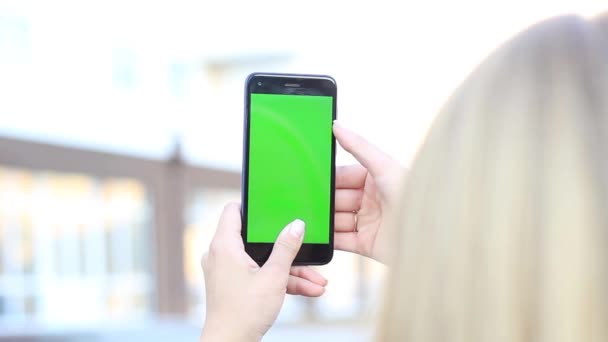 Κορίτσια τα χέρια κρατώντας ένα κινητό τηλέφωνο με μια πράσινη οθόνη. ΧΡΩΜΑ κλειδί — Αρχείο Βίντεο